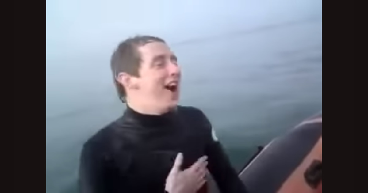 Rapaz empurra amigo em cima de tubarão no mar