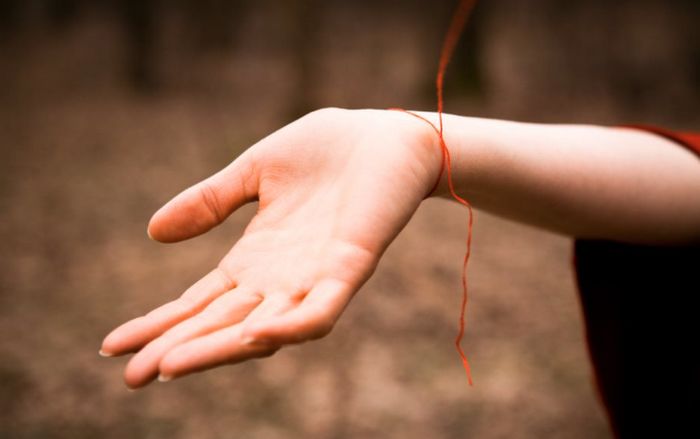 O que significa um fio vermelho amarrado no pulso?